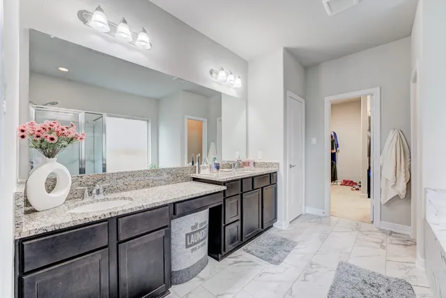 a spacious bathroom with a granite countertop sink and a mirror