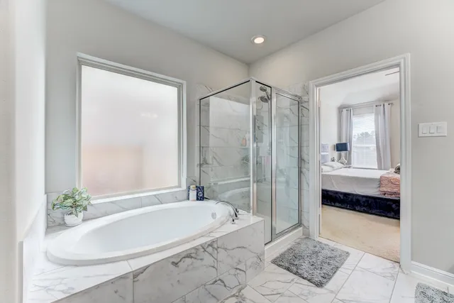 a bathroom with a tub shower and sink