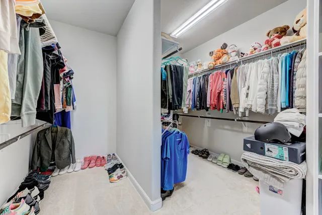 a view of walk in closet with clothes