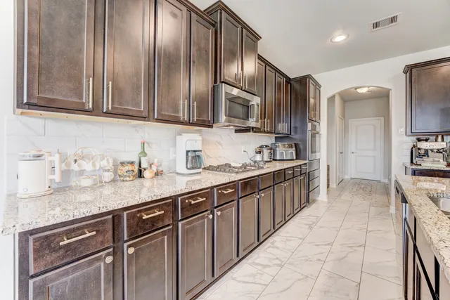 a kitchen with stainless steel appliances granite countertop a sink stove and cabinets
