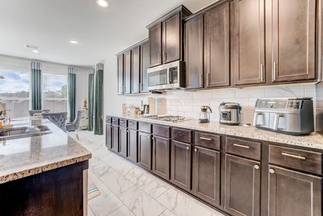 a kitchen with stainless steel appliances granite countertop a sink stove and cabinets