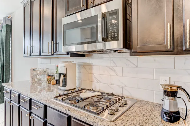 a kitchen with stainless steel appliances granite countertop a sink stove and cabinets