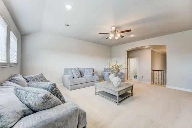 a living room with furniture and a ceiling fan