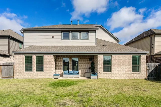 a view of a white house with large windows and a yard