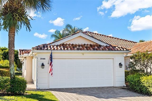 View of front facade featuring driveway, stucco siding, and a tiled roof