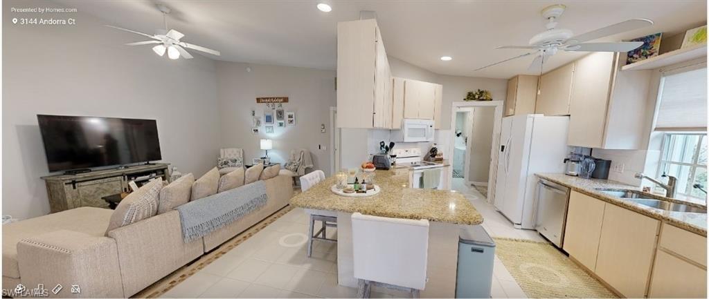 3144 Andorra Court Naples, FL 34109 - Photo 18 of 18 Kitchen featuring ceiling fan, open floor plan, white appliances, a breakfast bar, and a peninsula