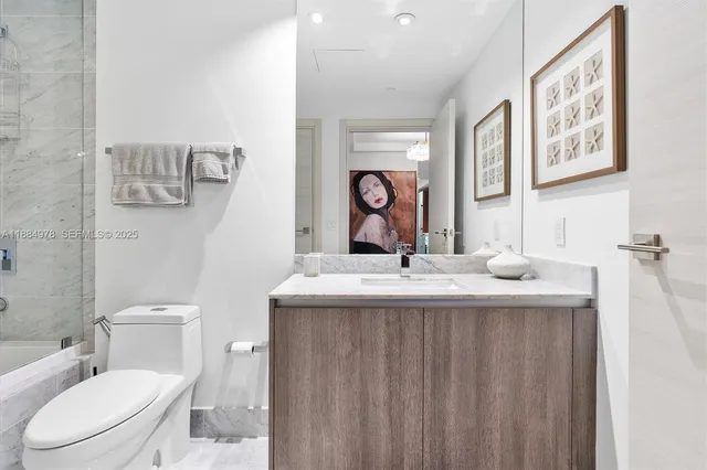 a bathroom with a double vanity sink mirror and toilet