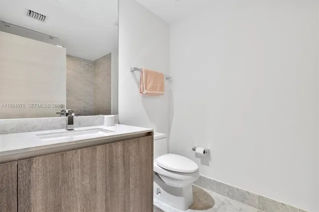 a view of a kitchen with fridge and wooden floor