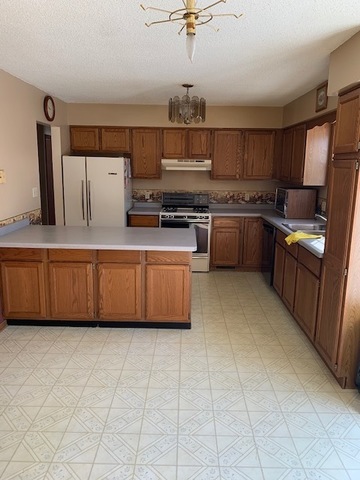 400 Wayne Road Rochelle, IL 61068 - Photo 6 of 9 a kitchen with stainless steel appliances a sink a stove a microwave a sink a refrigerator and cabinets
