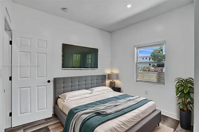 a bedroom with a bed and a potted plant