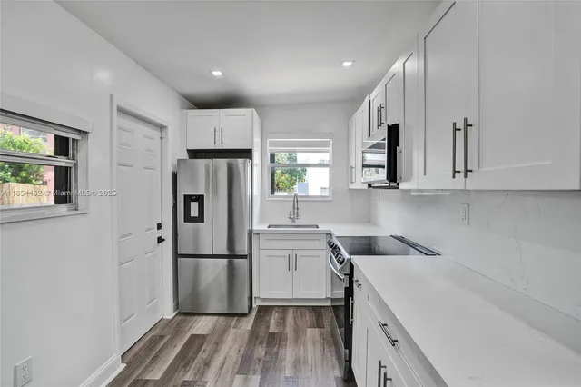 a view of kitchen with wooden floor and white wall
