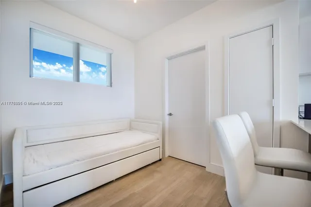 a bedroom with a bed and large window