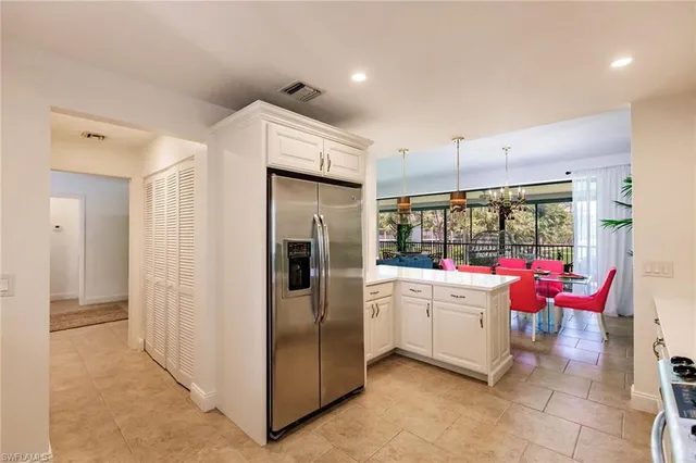 a kitchen with stainless steel appliances kitchen island granite countertop a refrigerator and a sink