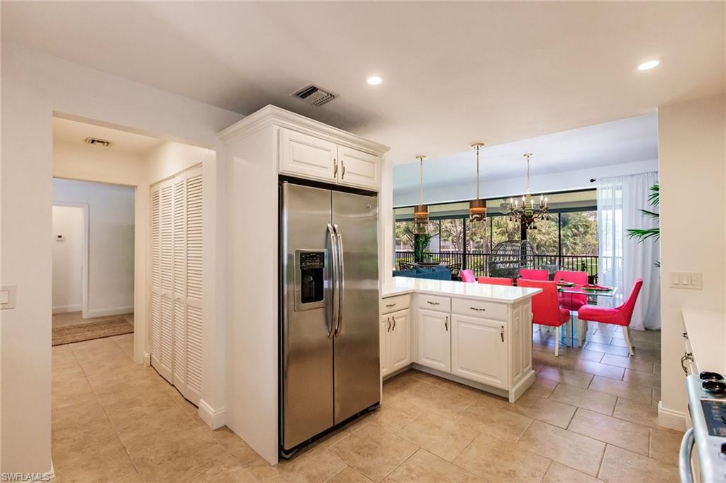 22 Cypress View Drive, Unit B22 Naples, FL 34113 - Photo 15 of 39 a kitchen with stainless steel appliances kitchen island granite countertop a refrigerator and a sink