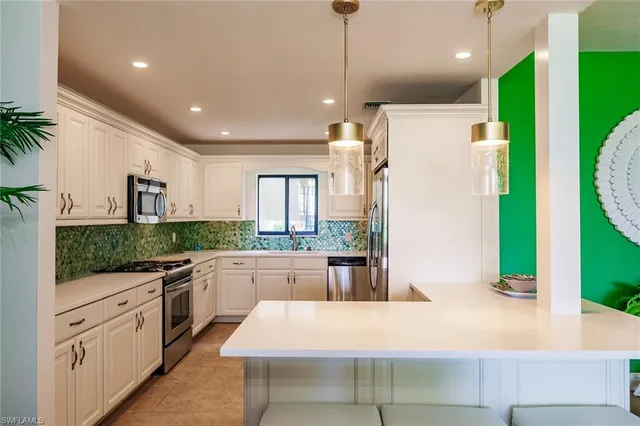 a large kitchen with stainless steel appliances kitchen island granite countertop a table and chairs in it