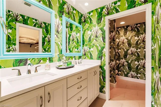 a bathroom with a granite countertop sink and a window