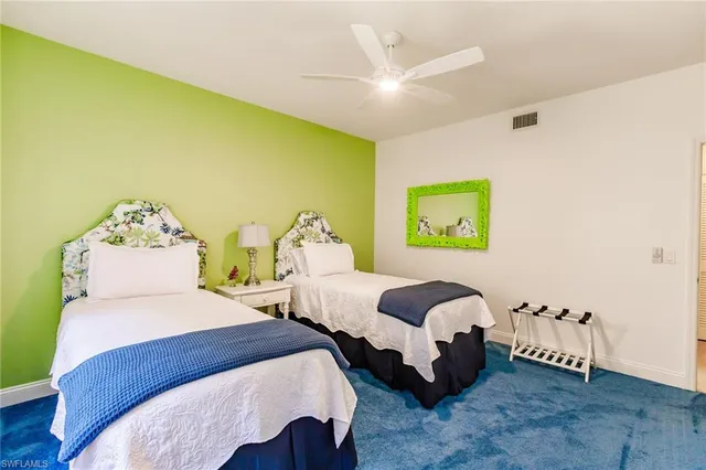 a bedroom with 2 bed and a chandelier