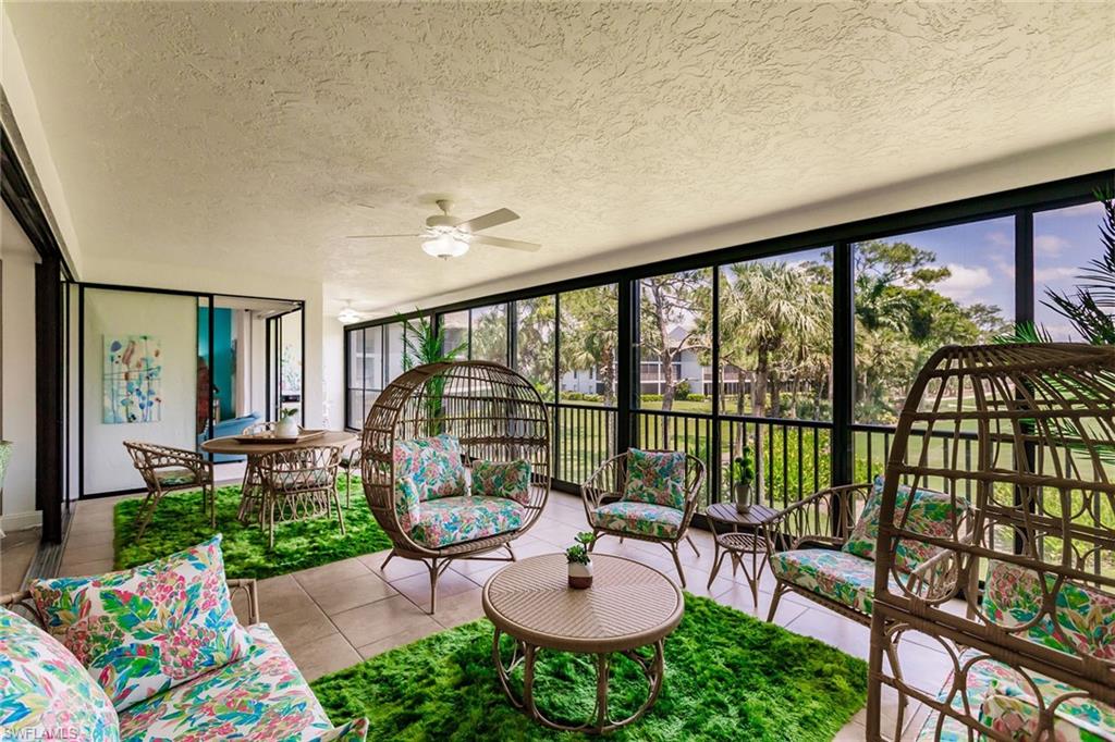 22 Cypress View Drive, Unit B22 Naples, FL 34113 - Photo 32 of 39 a living room with furniture and a floor to ceiling window
