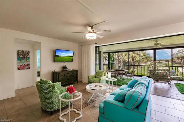 a living room with furniture a flat screen tv and a large window
