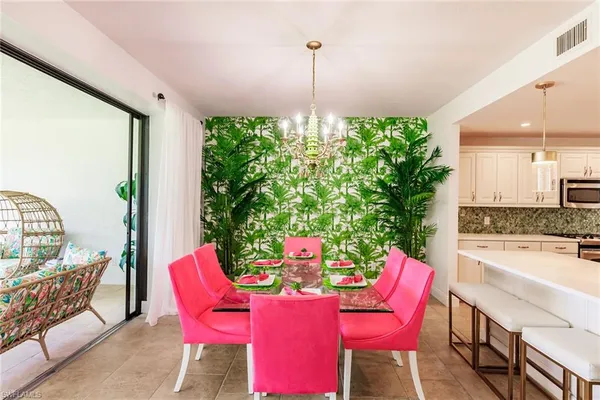 a dining room with furniture a chandelier and wooden floor
