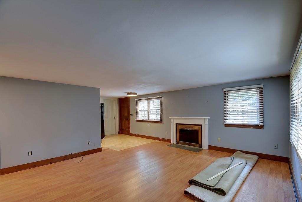 96 Shepard Road Sturbridge, MA 01566 - Photo 17 of 28 an empty room with windows fireplace and wooden floor