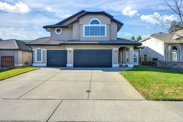 a view of a house with a yard and garage