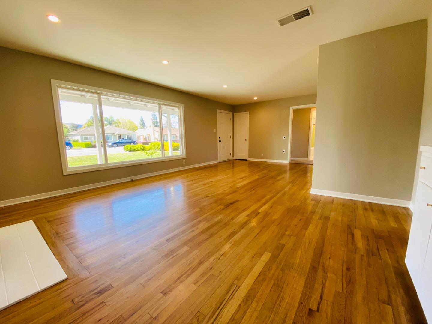 15107 Woodard Road San Jose, CA 95124 - Photo 4 of 20 a view of an empty room with wooden floor and a window