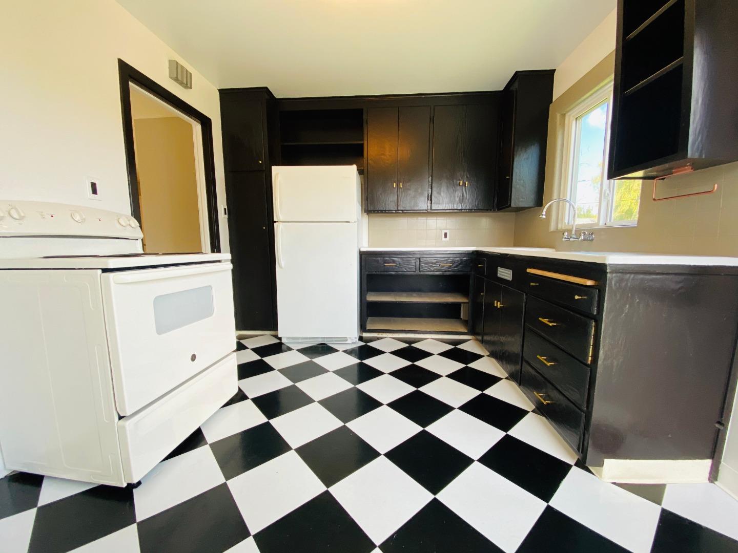 15107 Woodard Road San Jose, CA 95124 - Photo 7 of 20 a kitchen with a checkered floor and white cabinets