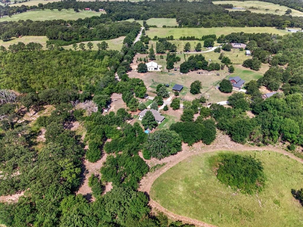 531 VZ County Road Eustace, TX 75124 - Photo 30 of 35 Expansive property featuring wooded areas, open grassy fields, multiple structures, and a winding unpaved road