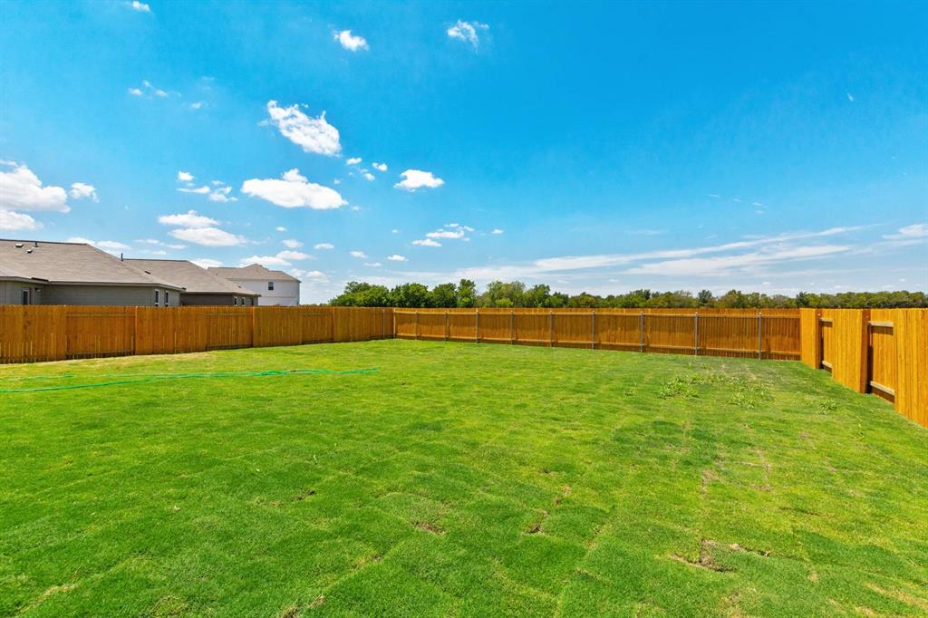16429 Farmhouse Lane Elgin, TX 78621 - Photo 21 of 22 Expansive fenced backyard featuring a generous grass lawn and natural wood privacy fencing