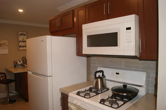 a white kitchen with a sink and a refrigerator