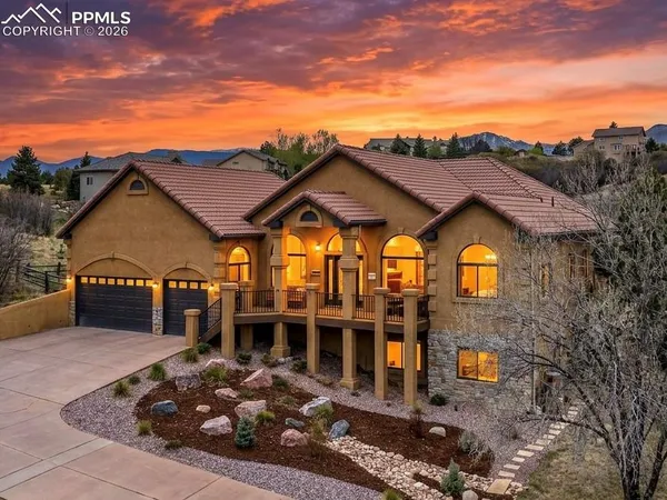 a view of a house with a yard and potted plants