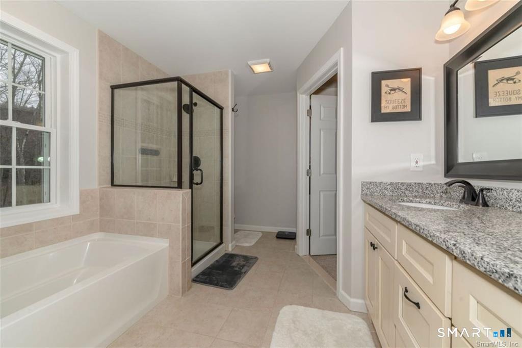 823 A Stone Road Windsor, CT 06095 - Photo 27 of 38 a bathroom with a granite countertop tub sink and mirror