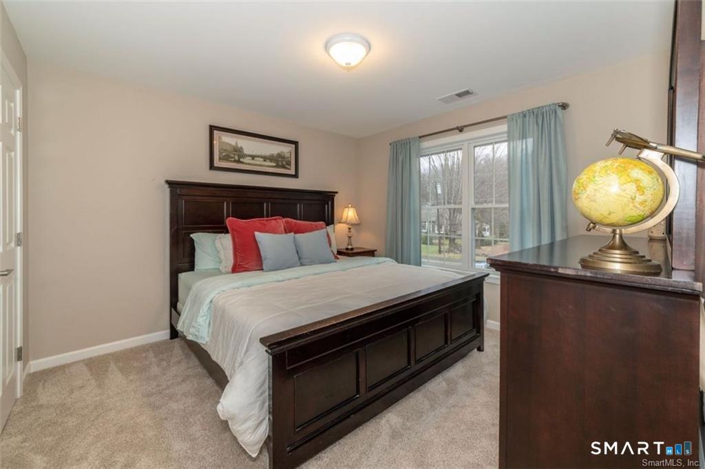 823 A Stone Road Windsor, CT 06095 - Photo 28 of 38 a bedroom with a bed and a chandelier