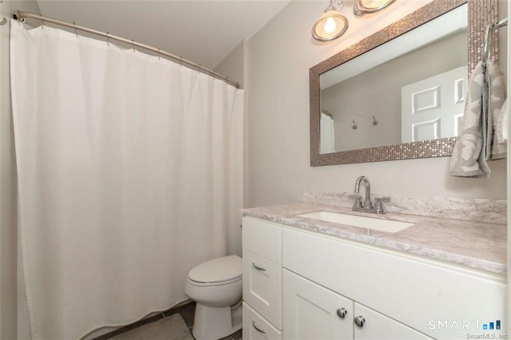 823 A Stone Road Windsor, CT 06095 - Photo 29 of 38 a bathroom with a granite countertop sink and a mirror