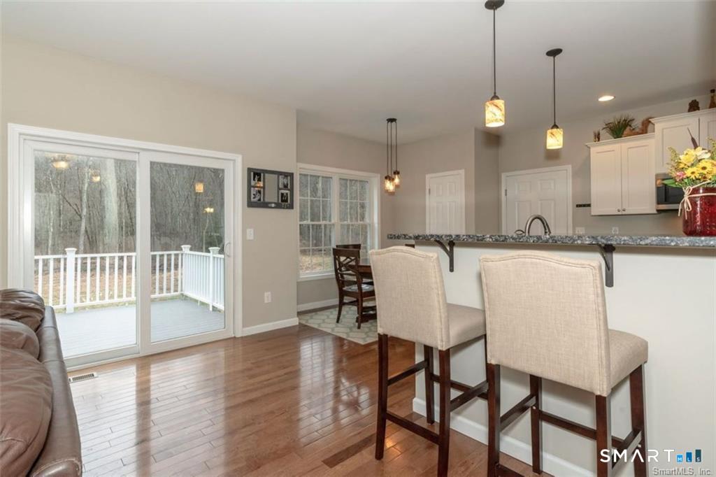 823 A Stone Road Windsor, CT 06095 - Photo 38 of 38 a dining room with wooden floor a chandelier a glass table and chairs
