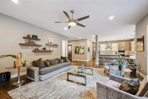 a living room with furniture kitchen view and a chandelier