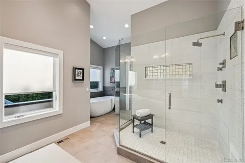 a spacious bathroom with a double vanity sink a mirror and a shower