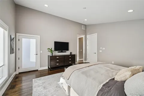 a bedroom with a bed and a flat tv screen on the dresser