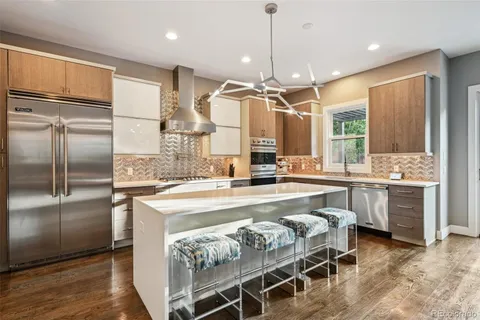 a large kitchen with kitchen island a large center island and stainless steel appliances
