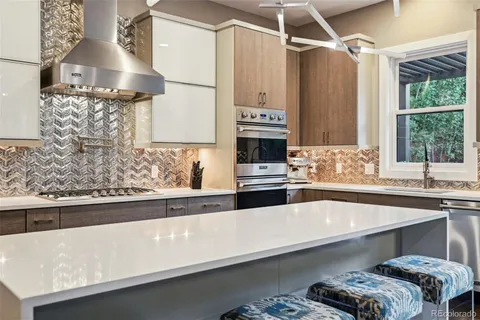 a kitchen with stainless steel appliances granite countertop a sink a stove and a microwave