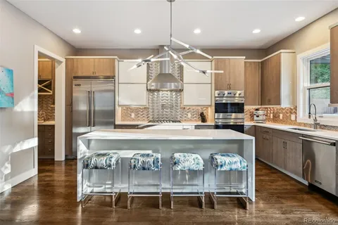 a kitchen with kitchen island granite countertop a stove and a wooden floors