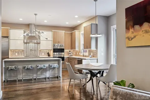a kitchen with stainless steel appliances kitchen island granite countertop a table and chairs in it