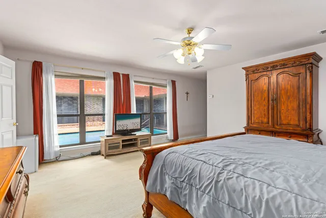 a bedroom with a bed and large windows