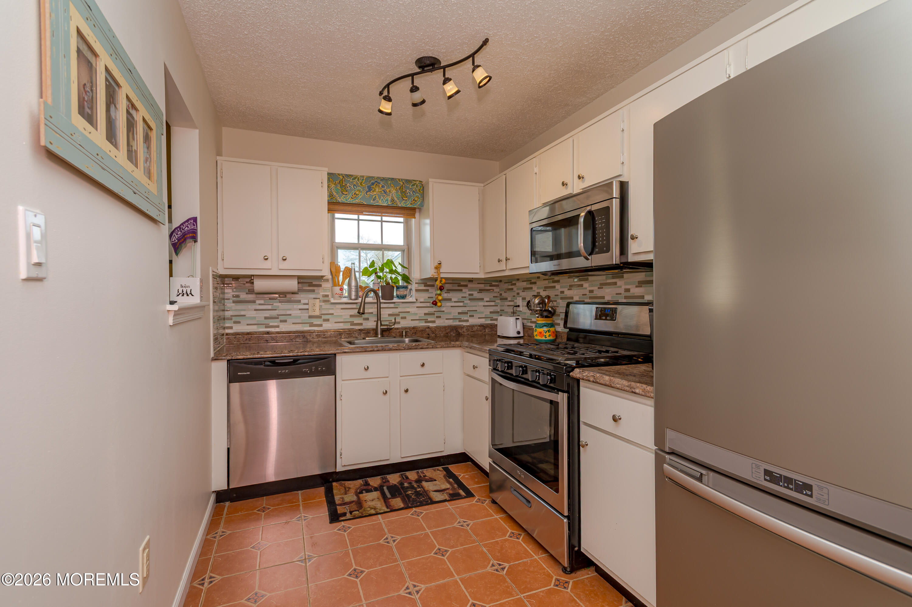 45 Datchet Close Freehold, NJ 07728 - Photo 12 of 22 a kitchen with stainless steel appliances granite countertop a stove a sink and a refrigerator