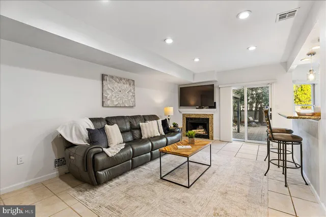 a living room with furniture a fireplace and a flat screen tv
