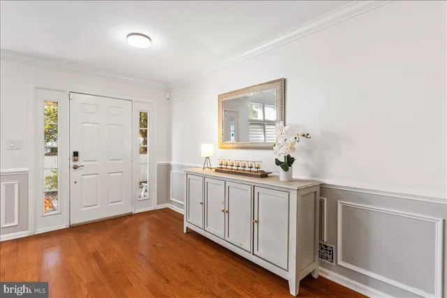 a kitchen with stainless steel appliances a white cabinets and a wooden floor