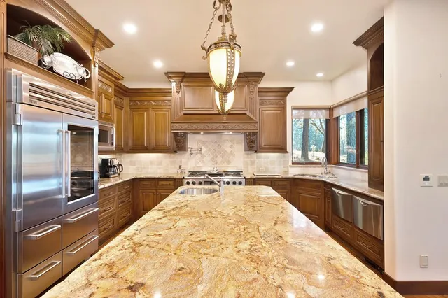 a large kitchen with kitchen island a large island in the center and a large window