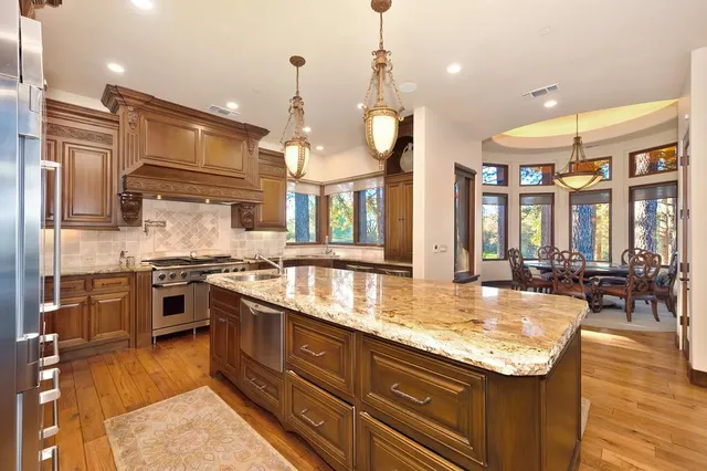 a kitchen with stainless steel appliances granite countertop a refrigerator and cabinets