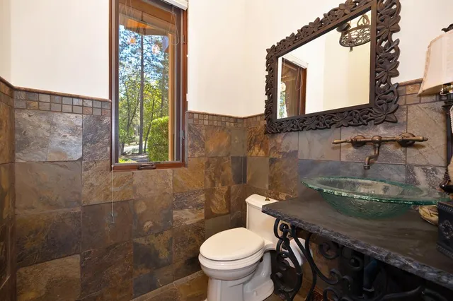 a bathroom with a granite countertop sink a mirror and shower